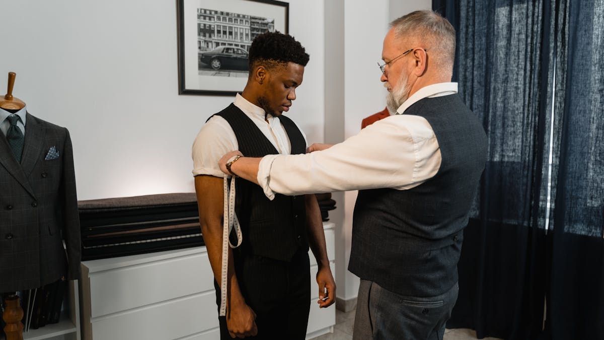 Tailor measuring a man's chest with a soft tape measure for suit sizing