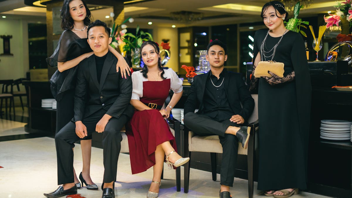 Stylish group of young adults in unique formal attire posing at a classy event -- the kind of looks that are reshaping prom culture in 2026